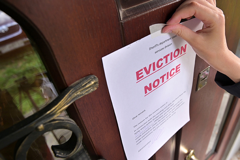 Civil servant sticks a notice of eviction of the tenant, close up